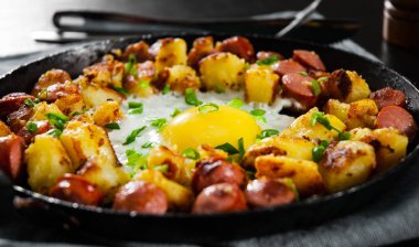 sosis ve patates ahşap masa üzerinde bir tavada kızarmış yumurta