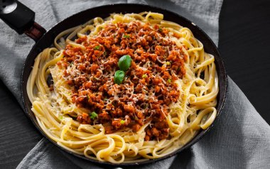 Geleneksel makarna spagetti bolognese bir tavada koyu ahşap arka plan üzerinde