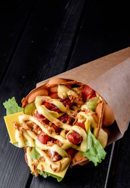 Hong Kong waffle sandviçi, siyah ahşap masa arkasında sosis, peynir ve sebze.