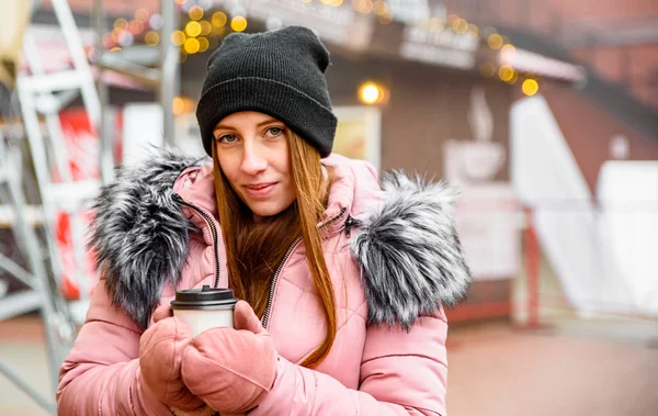 街の通りの冬に手にコーヒーのカップを持つ若い女性 — ストック写真