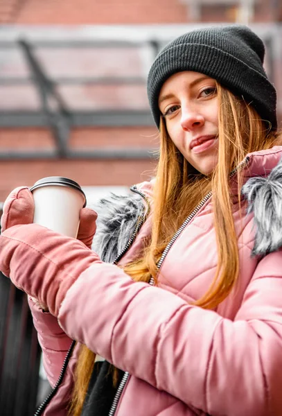 街の通りの冬に手にコーヒーのカップを持つ若い女性 — ストック写真