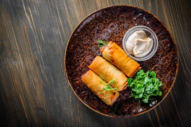 Tahta masa arkasında karides ve sosisli börek.