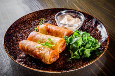 Tahta masa arkasında karides ve sosisli börek.