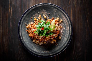 Tavuklu kızarmış pilav ve ahşap masa arkasında sebzeler.