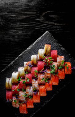  Somon, avokado, krem peynir, salatalık, pirinç, havyar, ahşap tabakta yılan balığı.