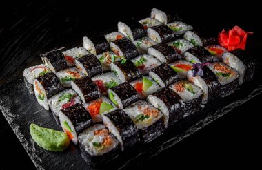 Somon, avokado, krem peynir, salatalık, pirinç, havyar, ahşap tabakta yılan balığı.