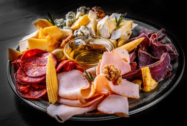 Domuz pastırmalı, peynirli, etli, salamlı, siyah ahşap masadaki jambon.