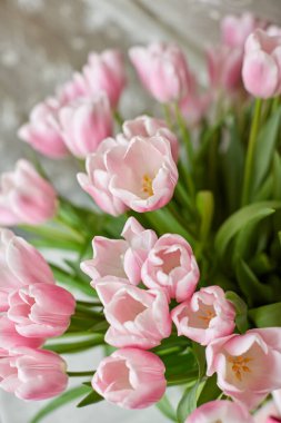 Masasında pembe laleler olan bir vazo ve dekor.