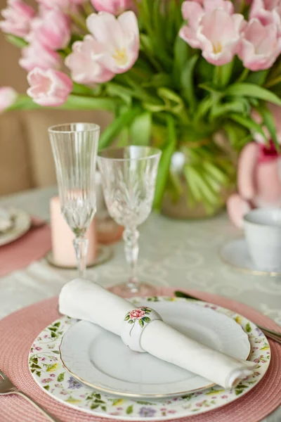 Decor and spring table setting is a vase with pink tulips