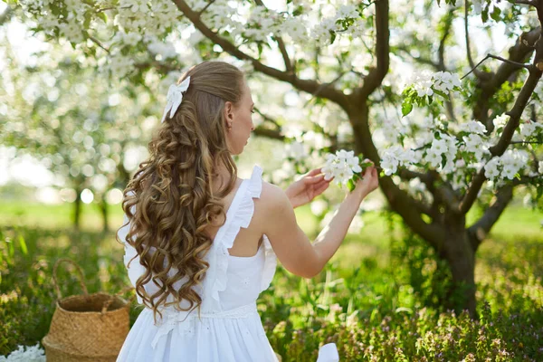 Den vackra flickan blondinen i blommande äppelträd trädgård — Stockfoto