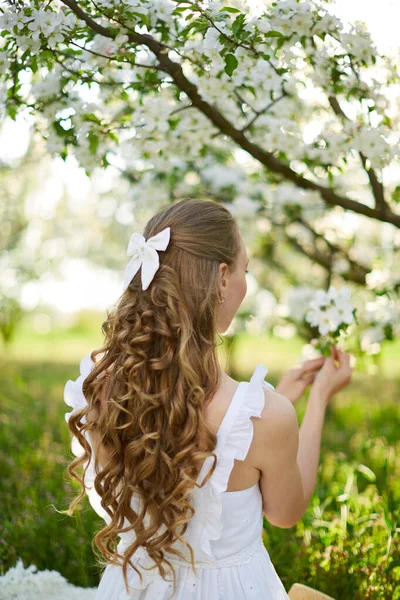 La hermosa chica la rubia en el floreciente jardín de manzanos — Foto de Stock