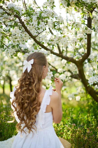 Güzel kız çiçek açan elma ağaçlarının bahçesindeki sarışın. — Stok fotoğraf