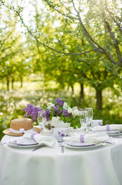 春の庭で休日の装飾されたダイニングテーブル テーブルの上の花瓶にライラックの花 パープルスタイル フランス プロバンス — ストック写真