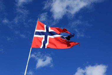 esen rüzgara karşı mavi gökyüzü ile bulut içinde bir Norveç bayrağı