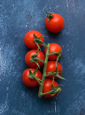 Kiraz domates asma üzerinde. Mavi beton masa artalanını. Üstten Görünüm, yukarıdan görünüm.