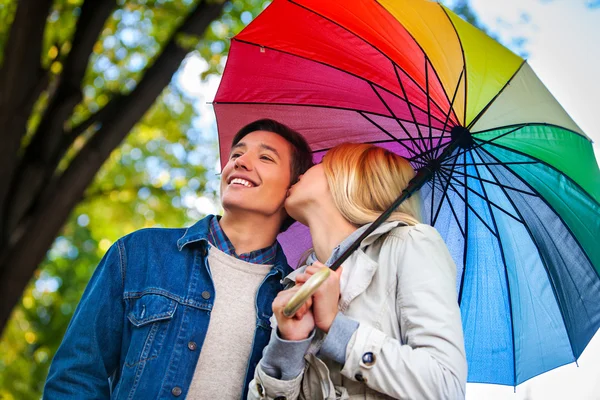 Loving couple on romantic date under autumn umbrella. — Stock Photo, Image