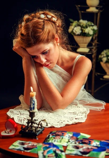Smutná dívka v svatební šaty uhappy pohledu rodinné fotografie. — Stock fotografie