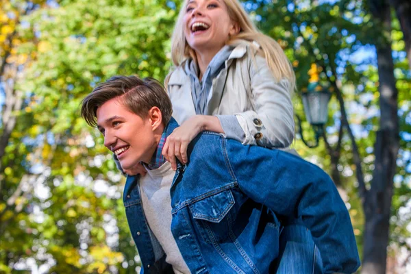 Junges Paar umarmt und flirtet im Herbstpark. — Stockfoto