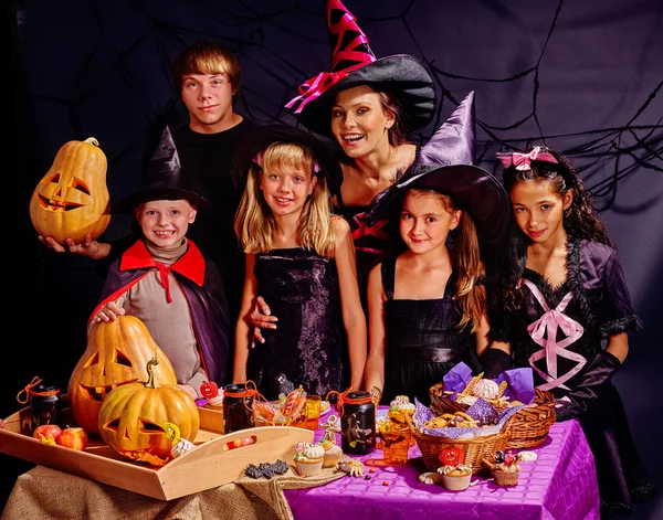 Crianças na festa de Halloween fazendo abóbora com adulto . — Fotografia de Stock