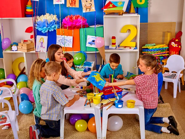 Kinder mit Lehrerin malen im Kindergarten auf Papier . — Stockfoto