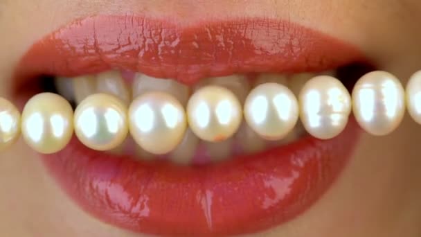 Close-up van vrouwelijke lippen en parelmoer kraal. Dental concept. — Stockvideo