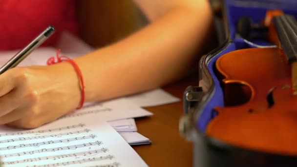 Chica compone música en hoja de música libro  . — Vídeos de Stock