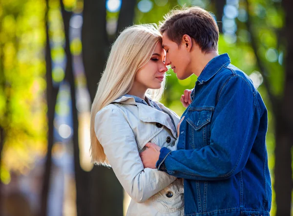 Jovem casal abraçando e ter olhos fechados no parque de outono . — Fotografia de Stock