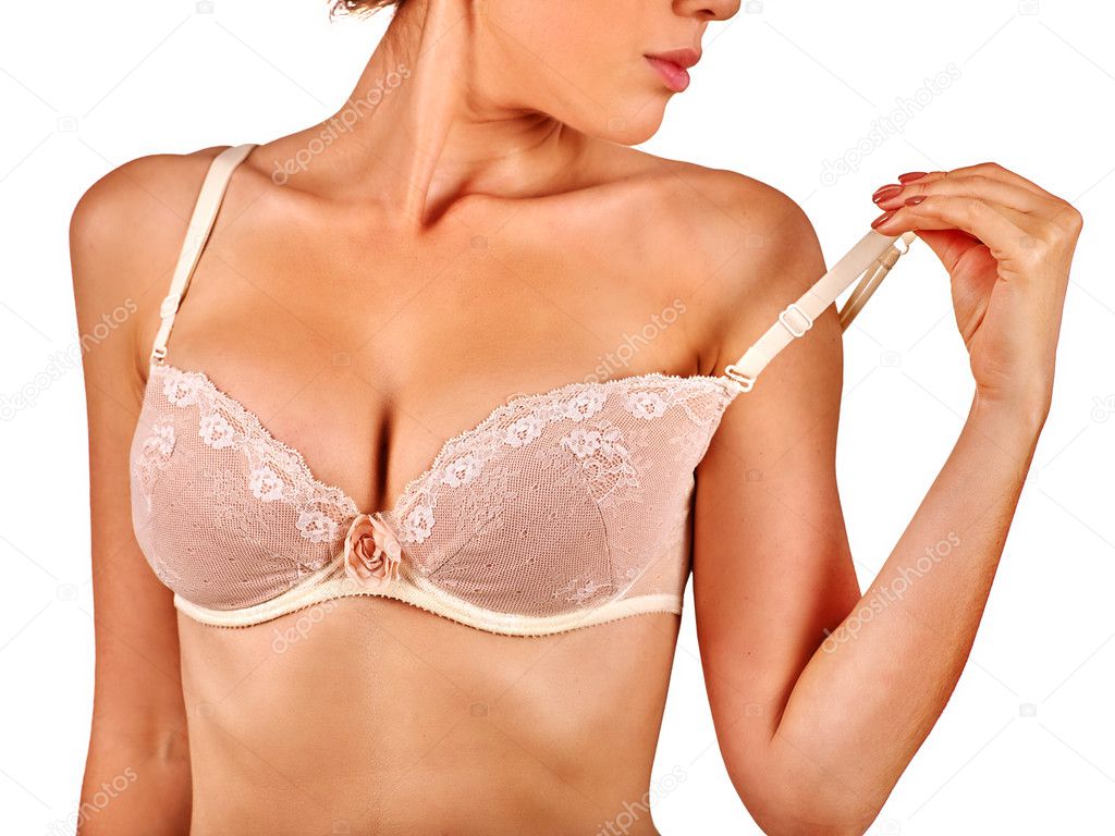 Young woman examines her breasts wearing bra.