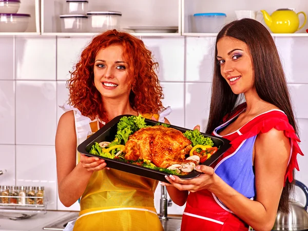 Girls together hold tray of fried chicken at kitchen. — Stock Photo, Image