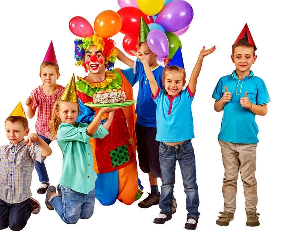 Payaso sosteniendo pastel en cumpleaños con niños en grupo . — Foto de Stock
