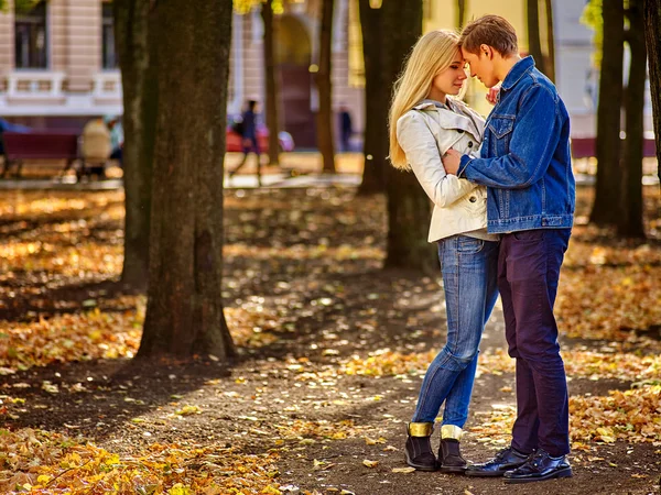 Młoda para, przytulanie i flirty w parku. Jesienne tło miasta. — Zdjęcie stockowe