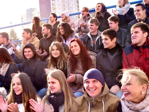 Sport fans clapping and singing on tribunes. Winter weather. — Stockfoto