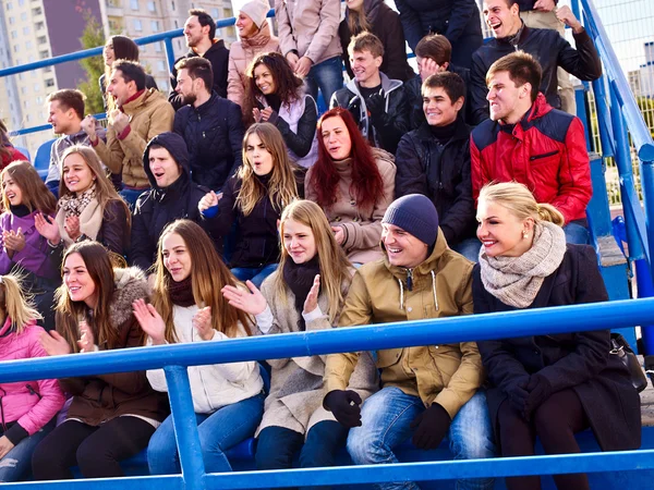 Sport fans clapping and singing on tribunes. Handrails in foreground. — Stockfoto