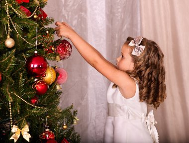 Çocuk Noel ağacı süslemek.