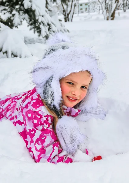 Little girl in winter clothes under snow fir-tree. — Stock Photo, Image