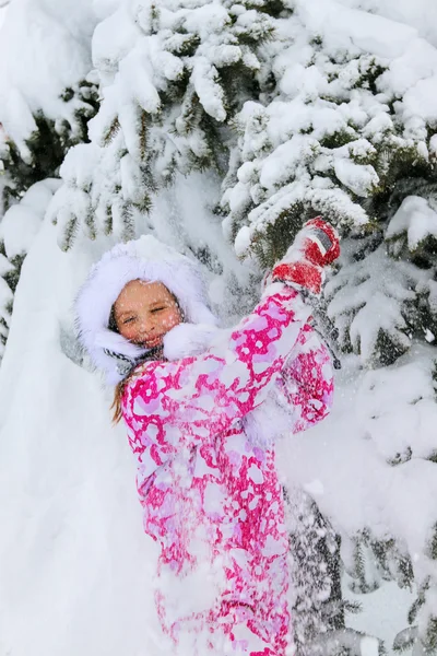 Criança em roupas de inverno e chapéu quente com neve caindo . — Fotografia de Stock