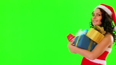 Santa şapka hediye kutusu tutan kadın. Yeşil arka plan.