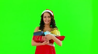 Santa şapka hediye kutusu tutan kadın. Yeşil arka plan.