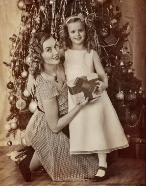 Çocuk ile anne Noel ağacı yakınındaki aile portresi.