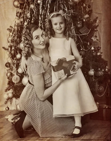 Family portrait of child with mother near Christmas tree. — Stock Photo, Image