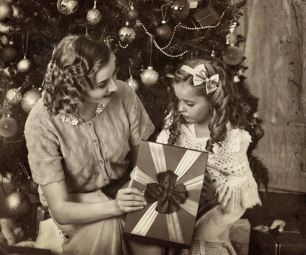 Kid met moeder in de buurt van de kerstboom. — Stockfoto