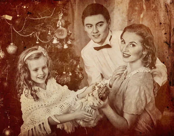 Vader knuffels zijn vrouw met dochter en dressing kerstboom. — Stockfoto