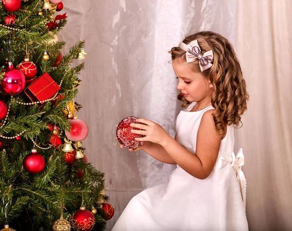 Kind schmückt Weihnachtsbaum allein zu Hause. — Stockfoto