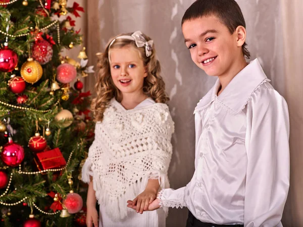 Enfants recevant des cadeaux sous l'arbre de Noël . — Photo