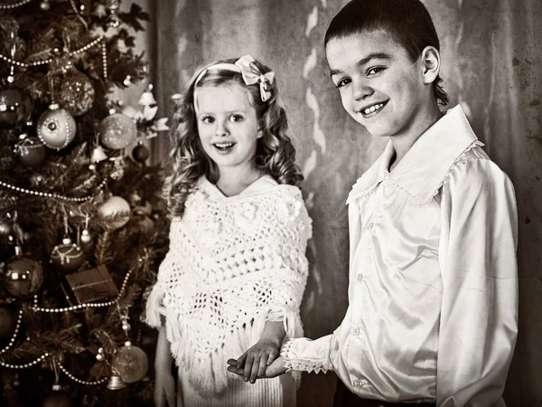 Black and white picture children under Christmas tree. — Stock Photo, Image