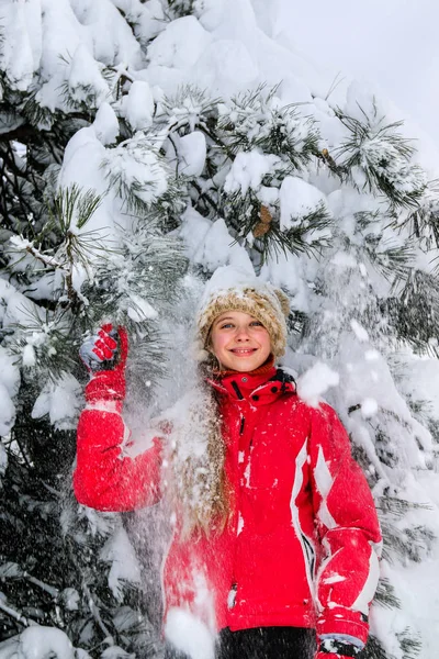 Teen girl stands against of snow-covered fir trees. — Stock Photo, Image