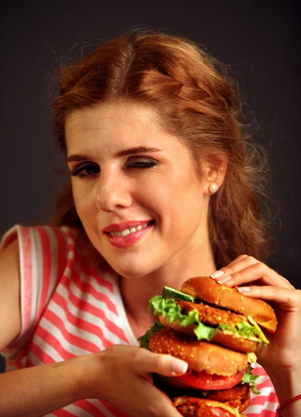 Žena jíst hamburger a mrknutí. Šťastný, student jíst oběd sendvič. — Stock fotografie