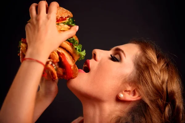 Mujer comiendo hamburguesa. Estudiante consume comida rápida . — Foto de Stock
