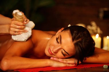 Kadın spa salonu masaj. Kadın topu terapi sıcak otlar var.