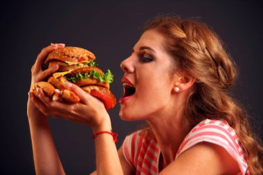 Kız bir hamburger uzanmış elinde tutarak onun ağzını açtı ve gözleri kapalı.